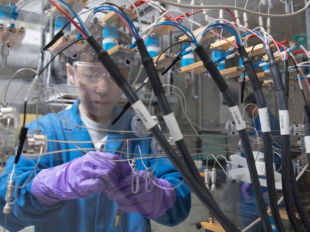 Scientist with rubber gloves and goggles working in a lab